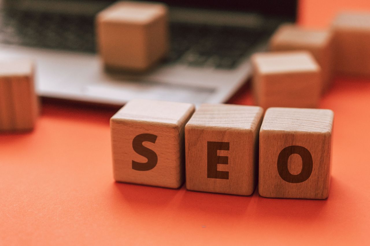 Wooden blocks arranged to spell SEO on a laptop keyboard illustrate digital marketing ideas.